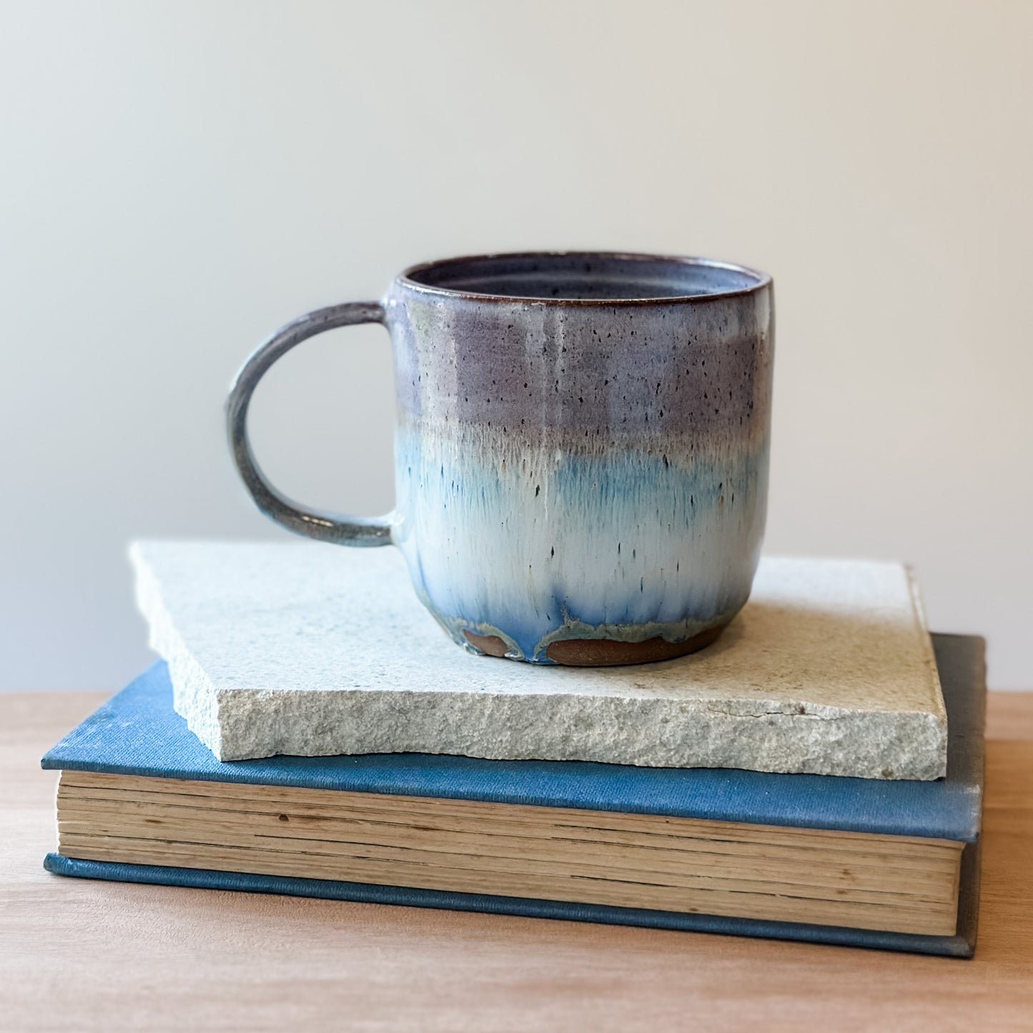 Ceramic mug with blue gradient on top of a tile