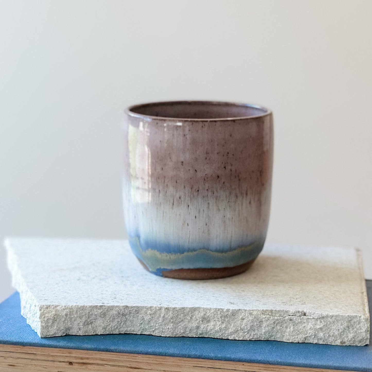 Ceramic cup with gradient color on a stone surface