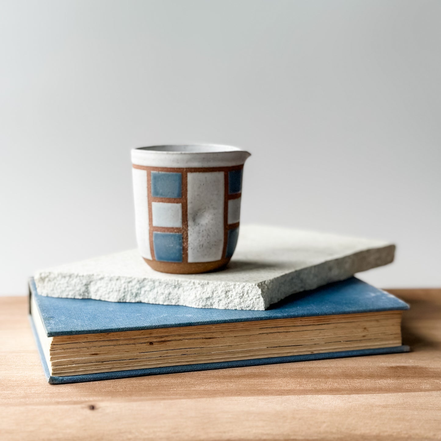 A creamer jug with a geometric pattern and blue glaze.