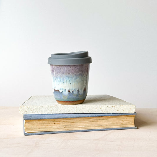 take-away keep cup on a tile with a light background.
