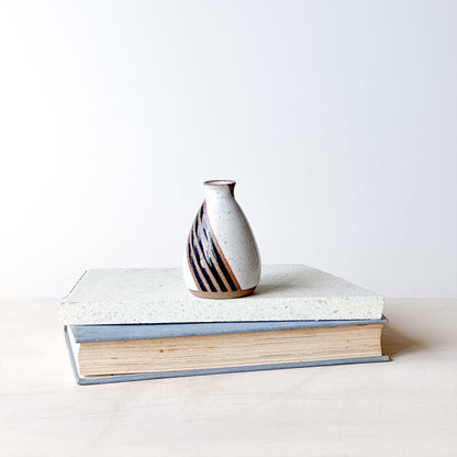 Ceramic vase on a book with a plain background