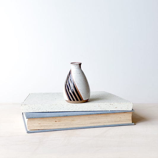 Ceramic vase on a book with a plain background
