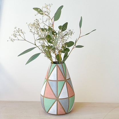 Geometric patterned vase with greenery on a light background