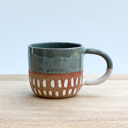 Ceramic Espresso mug with a textured design on a wooden surface and a light background