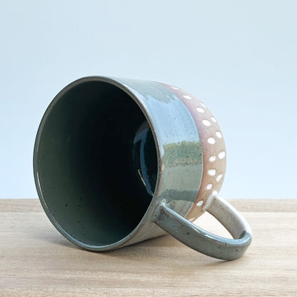 Ceramic mug with a handle on a wooden surface and a light background