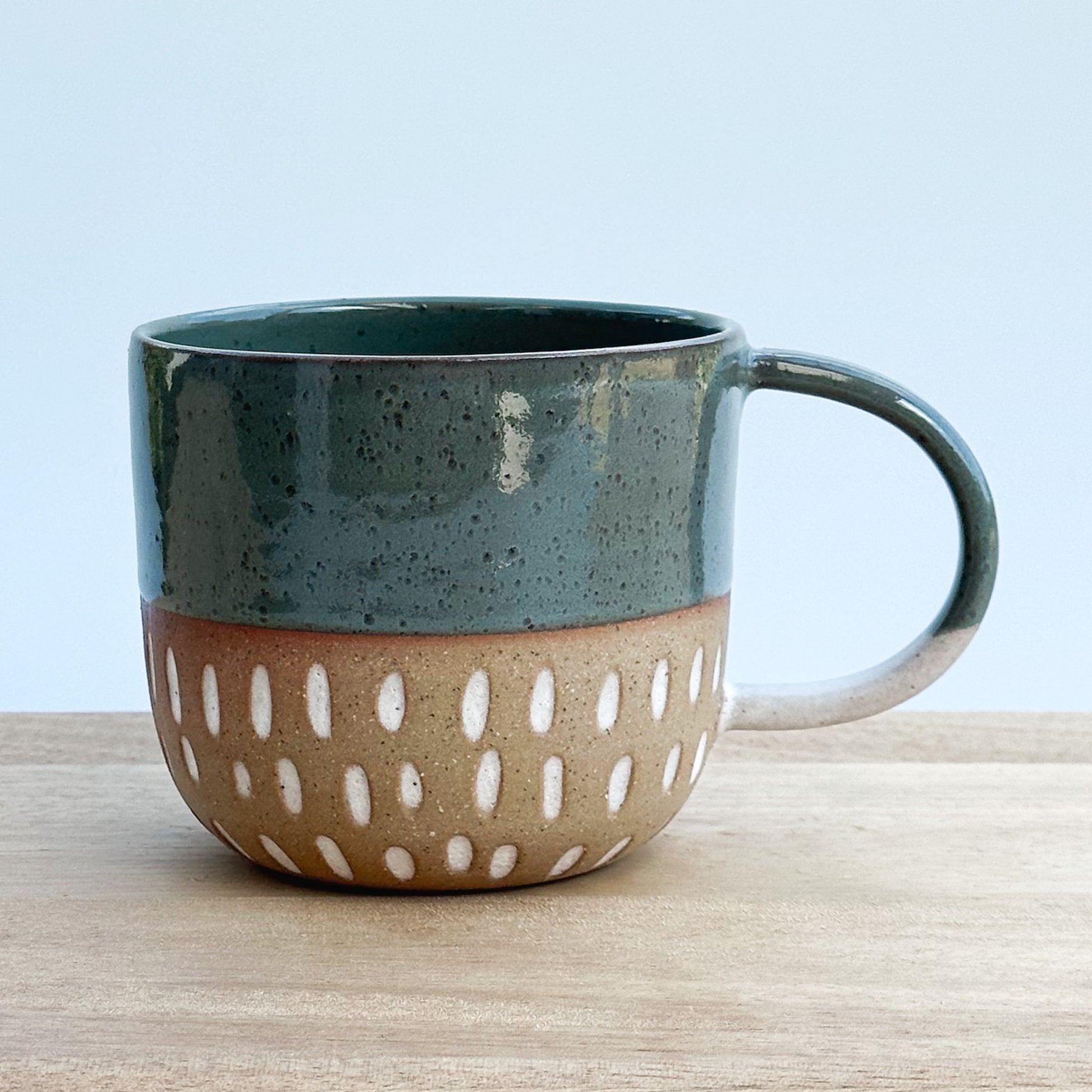 Ceramic mug with a two-tone design on a wooden surface