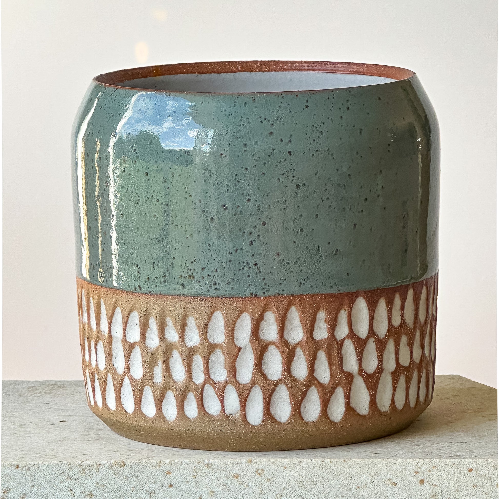 Ceramic planter with textured design on a light background