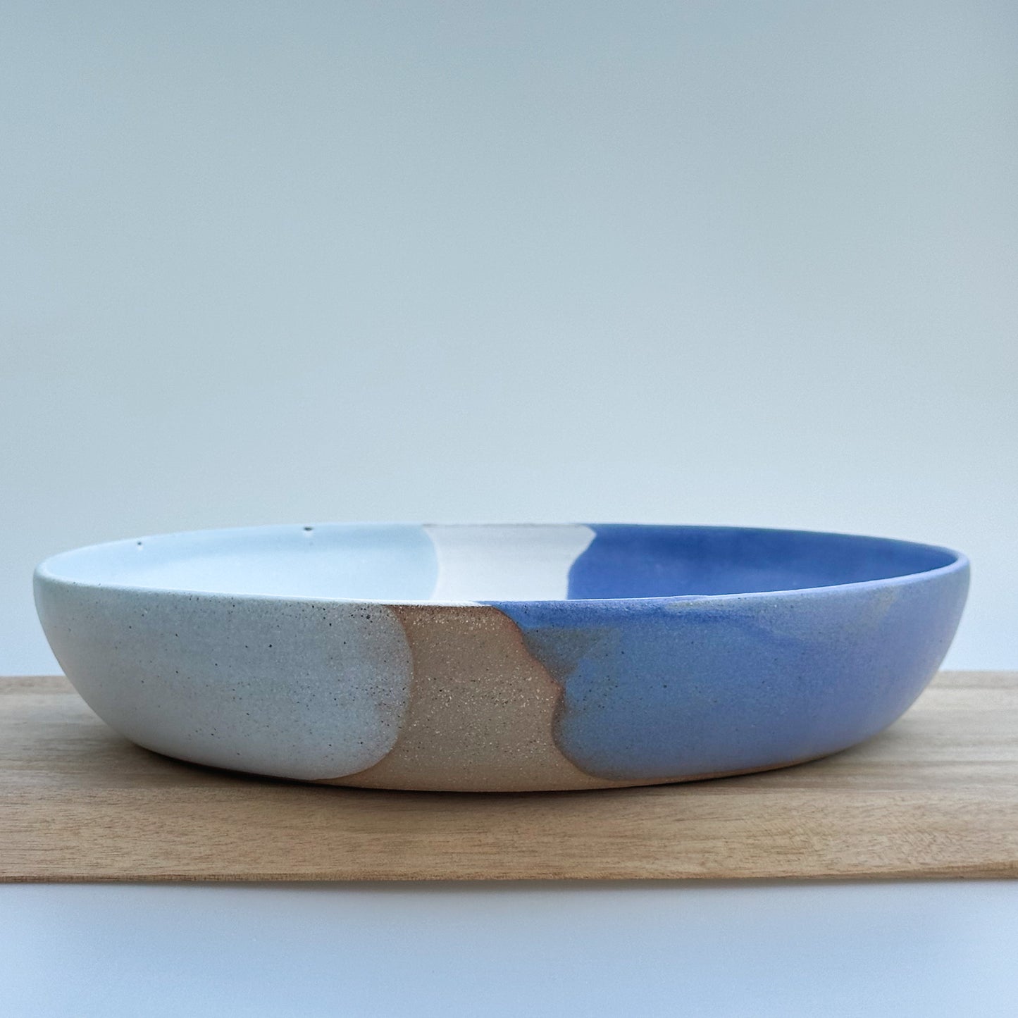 Ceramic bowl with blue and purple design on a wooden surface